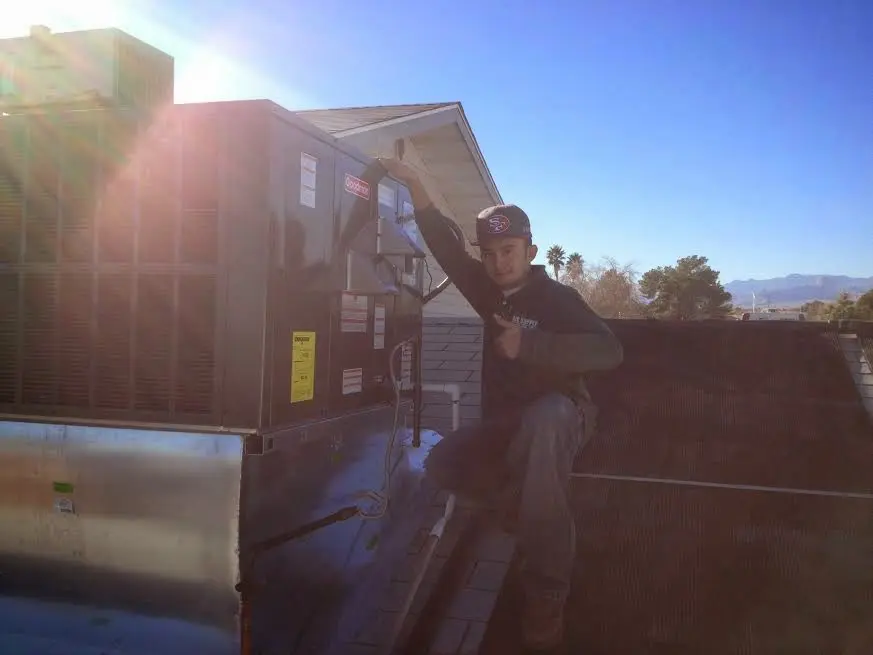 HVAC technician performing Air Duct Repair on a rooftop unit in Meridian